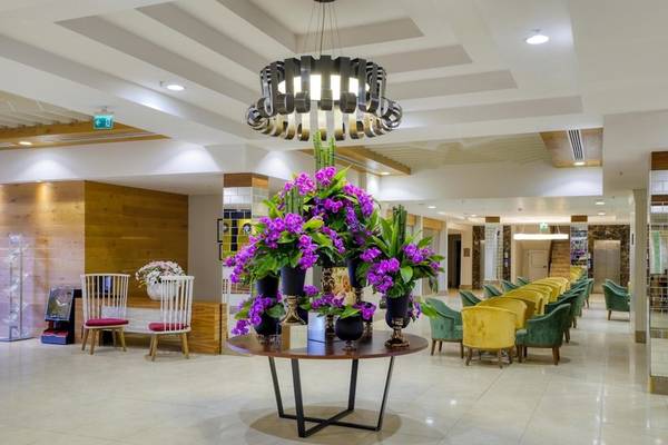 Lobby des Grand Park Lara Hotels mit Tisch, Blumen und Stühlen