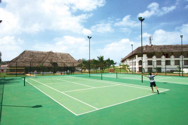 Tennisplatz im Sea Cliff Resort & Spa mit zwei Spielern und Gebäuden im Hintergrund.