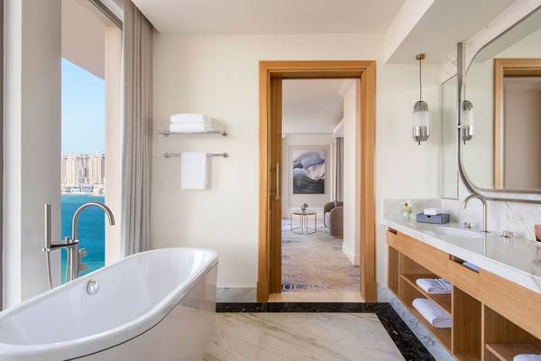 Das Badezimmer im St. Regis Doha mit Badewanne und Meerblick.