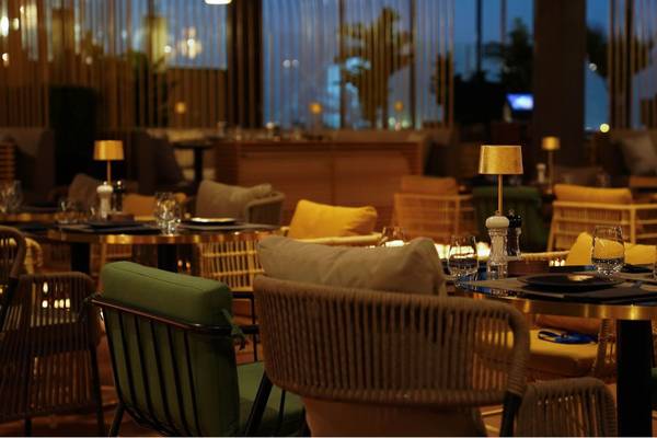 Innenansicht des Restaurants im St. Regis Doha mit Tischen, Stühlen und Lampen