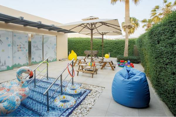 Kinder Lernzentrum im St. Regis Doha mit bunten Wandmalereien, Spielgeräten und Sitzmöbeln.