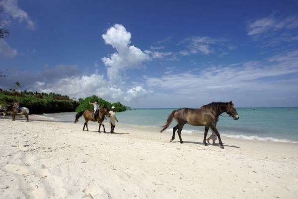 Menschen reiten auf Pferden am Strand des Sea Cliff Resort & Spa