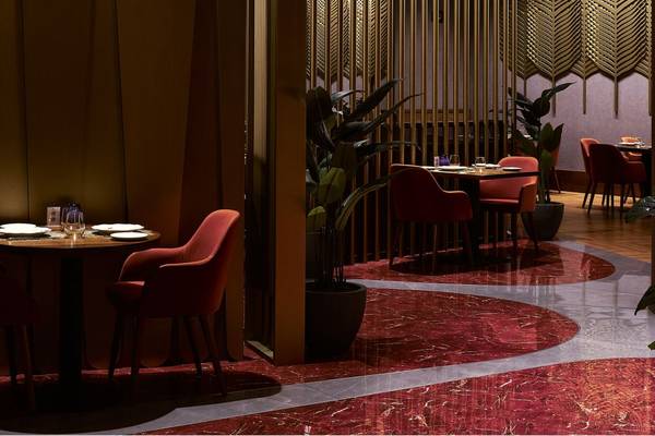 Innenbereich des St. Regis Doha Restaurants mit einem Tisch und Stühlen.