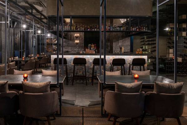 Innenansicht des St. Regis Doha Restaurants mit Tischen, Stühlen und einer Bar.