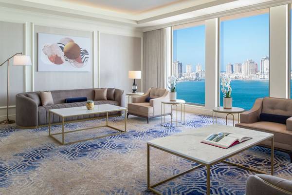 Das Wohnzimmer im St. Regis Doha mit Blick auf das Meer und die Stadt.