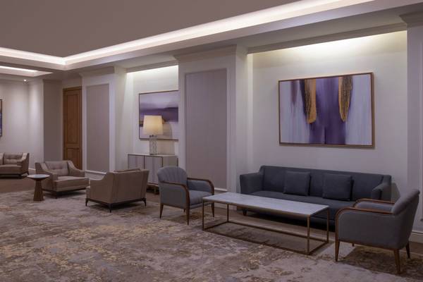 Lobby des St. Regis Doha Hotels mit Möbeln und Gemälden an der Wand.