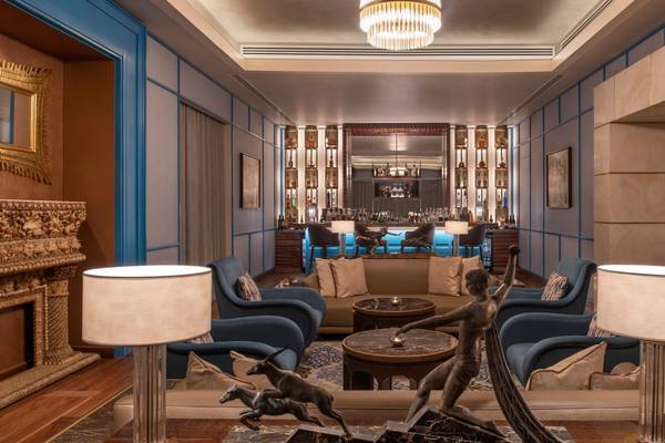 Innenansicht des St. Regis Doha Lounge mit Statue, Sofas, Tischen und Beleuchtung.