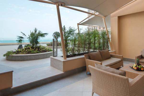 Terrasse im St. Regis Doha Hotel mit Blick auf das Meer und grüner Pflanzen