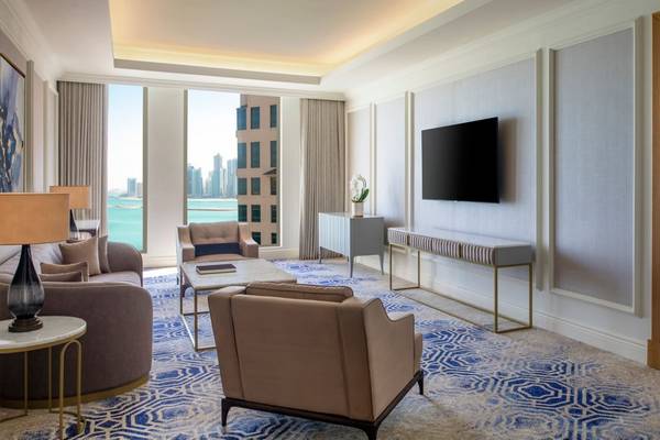 Innenansicht der Suite im St. Regis Doha mit Wohnzimmer und Schlafzimmerbereich.
