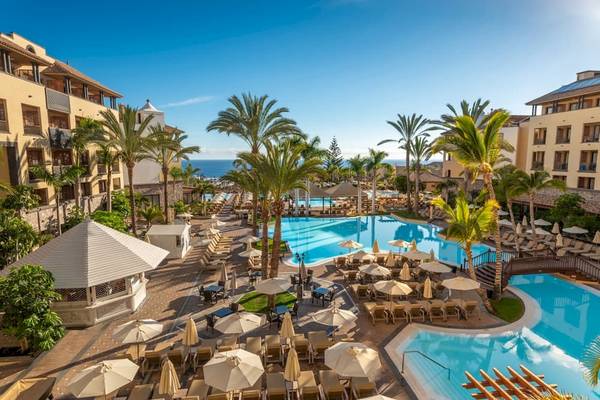 Poolbereich des GF Gran Costa Adeje Hotels mit vielen Liegen und Sonnenschirmen.