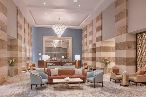 Lobby im St. Regis Doha Hotel mit großen Möbeln und Kronleuchter.