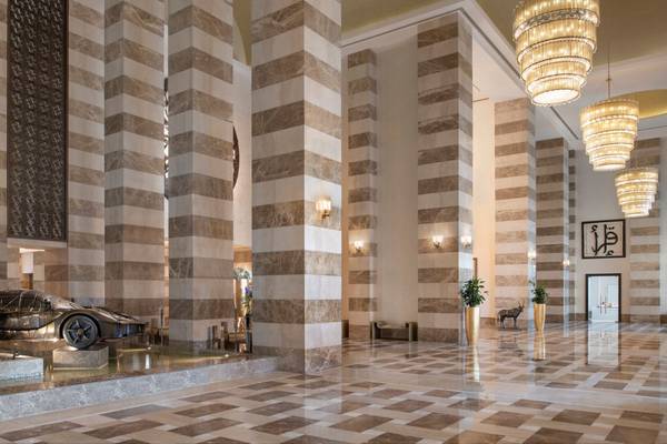Lobbyansicht des St. Regis Doha Hotels mit einem schwarzen Auto und Marmorboden.