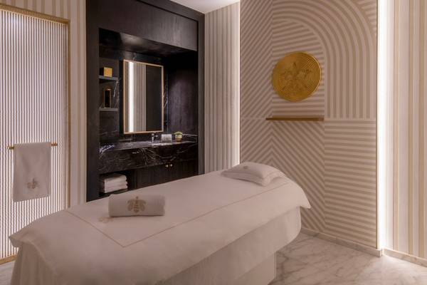 Spa-Behandlungsraum im St. Regis Doha mit Massagetisch, Wandverkleidung und Dekor.