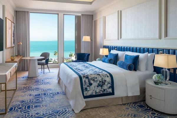 Luxuriöses Zimmer im St. Regis Doha mit Blick auf das Meer und moderne Einrichtung.