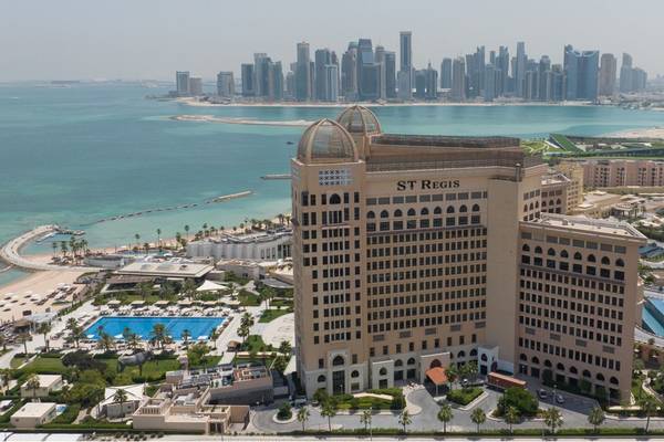 Außenansicht des St. Regis Doha Hotels mit Skyline und Pool im Vordergrund