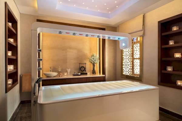 Modernes Badezimmer mit freistehender Badewanne, Marmorwand, Wasserhahn und Beleuchtung im Souq Al Wakra Hotel Qatar By Tivoli.