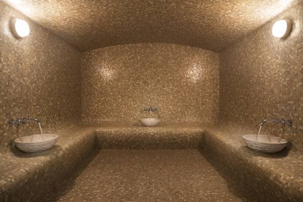 Innenansicht der Sauna im Souq Al Wakra Hotel Qatar By Tivoli mit drei Becken und beige gefliesten Wänden.