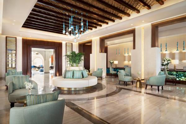 Innenansicht der Lobby des Souq Al Wakra Hotel Qatar By Tivoli mit Möbeln und Pflanzen.