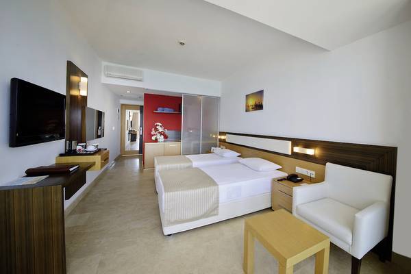 Hotelzimmer von Yalihan Una mit zwei Betten, Fernseher, Schrank und modernem Design.