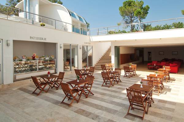 Außenbereich des Yalihan Una Hotels mit Sitzplätzen, Tischen und einer Konditorei