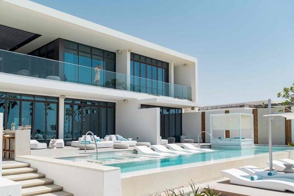 Außenbereich des Nikki Beach Resort & Spa Dubai mit Pool und Loungemöbeln.