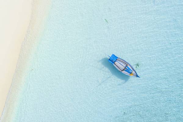 Luftaufnahme eines Bootes im klaren Wasser in der Nähe eines Strandes