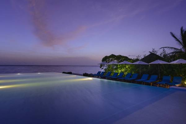 Infinity-Pool des Summer Island Maldives Hotels bei Nacht mit Blick auf den Ozean