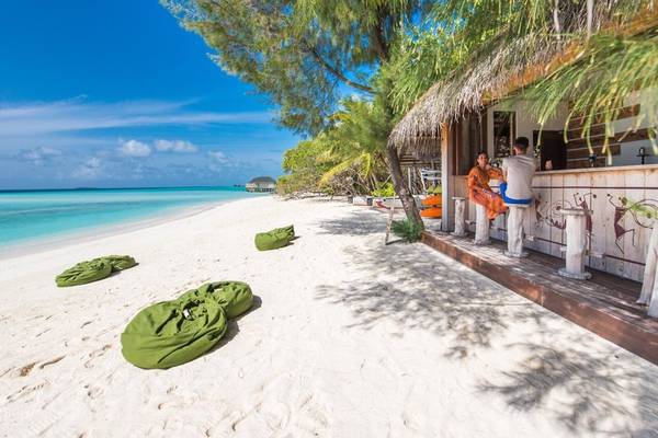 Strandbar des Summer Island Maldives Hotels mit zwei Gästen und Blick auf den Strand
