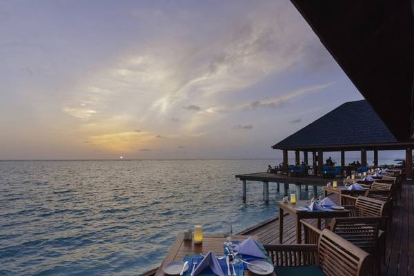 Terrasse des Summer Island Maldives Hotels bei Sonnenuntergang mit Blick aufs Meer