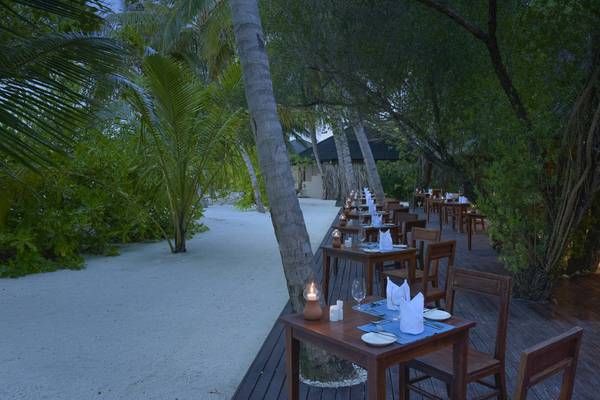 Abendessen auf der Terrasse im Summer Island Maldives Hotel bei Nacht mit brennenden Kerzen.