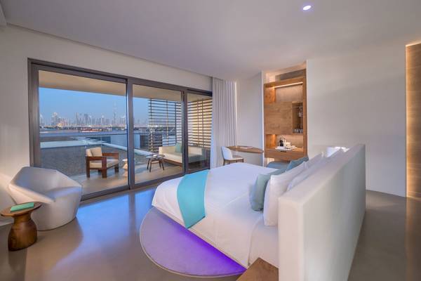 Schlafzimmer im Nikki Beach Resort & Spa Dubai mit Stadtblick und modernem Design.
