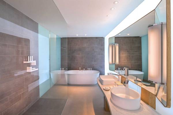 Badezimmer im Nikki Beach Resort & Spa Dubai mit Badewanne, Waschbecken und Spiegel.