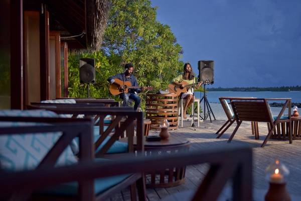 Zwei Musiker spielen Gitarre auf der Terrasse im Sommer Island Maldives Hotel.