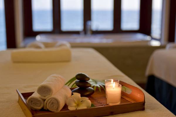 Massagetisch im Summer Island Maldives Hotel mit Kerzen, Blumen und Handtüchern
