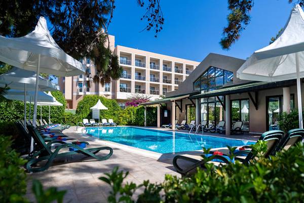 Außenpool des Turquoise Hotels mit Sonnenliegen und Schirmen an einem sonnigen Tag.