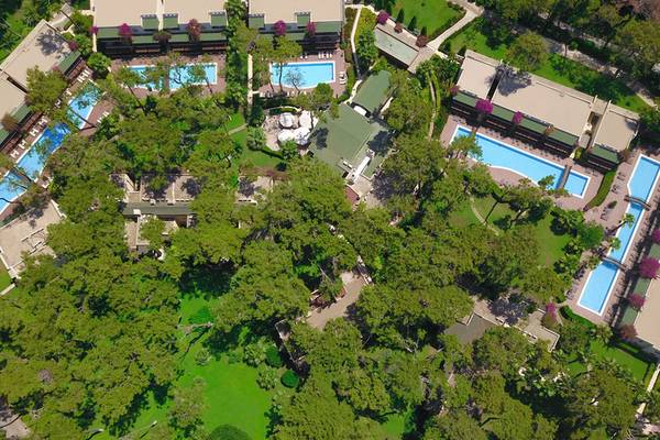 Aussenansicht des Turquoise Hotels von oben mit mehreren Swimmingpools und grünen Bäumen.