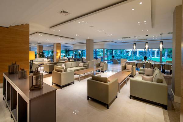 Lobby des Turquoise Hotels mit modernen Möbeln und großer Fensterfront.