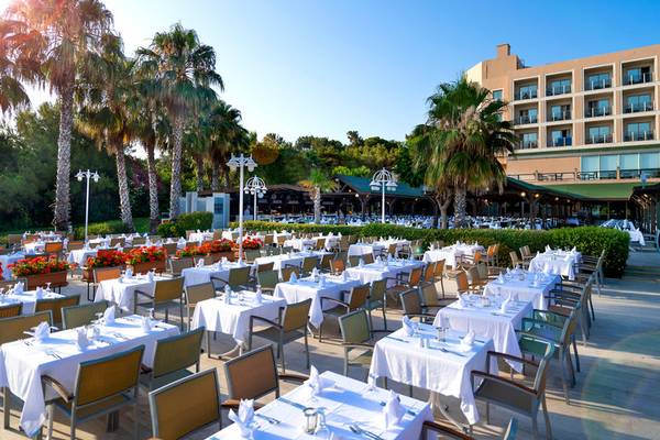 Außenbereich des Turquoise Hotels mit gedeckten Tischen und Palmen
