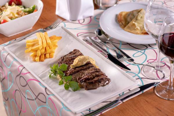 Ein Steakteller mit Pommes Frites und Salat im Turquoise Hotel.