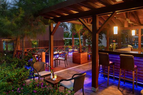 Terrasse des Turquoise Hotels mit beleuchteten Stühlen und Bar.