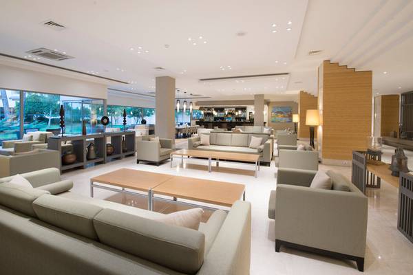 Lobby des Turquoise Hotels mit modernen Möbeln, großen Fenstern und heller Beleuchtung.