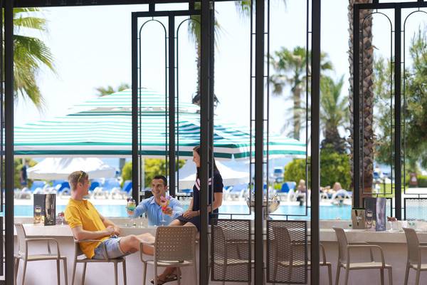 Zwei Männer und eine Frau sitzen an der Hotelbar im Turquoise Hotel und trinken Cocktails.
