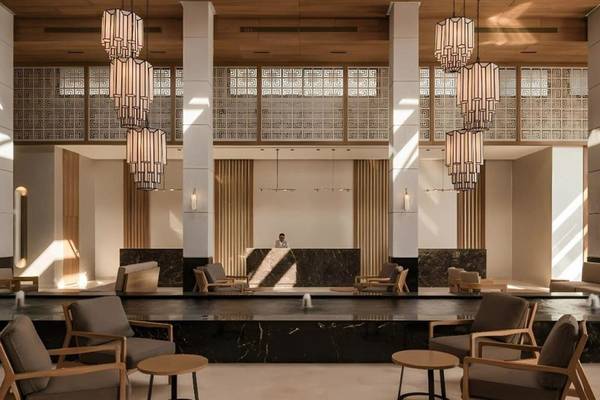 Lobby des JAZ Riviera Hotels mit Empfangstresen, Holzdecken, Marmorboden und modernen Möbeln.