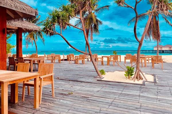 Restaurant mit Tischen und Stühlen auf der Strandterrasse im Brennia Kottefaru Maldives