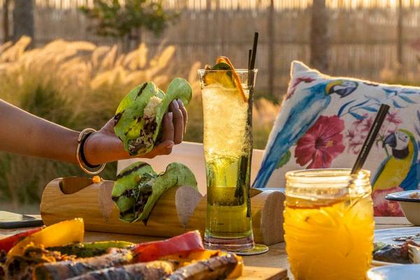 Frühstück im Garten des Nikki Beach Resort & Spa Dubai mit Obst, Sandwiches und Getränken.