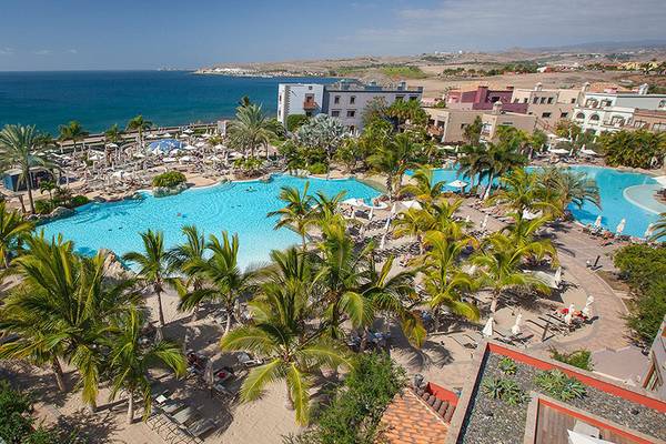 Luftaufnahme des Lopesan Villa del Conde Resorts und Thalasso mit großen Swimmingpools und Palmen.
