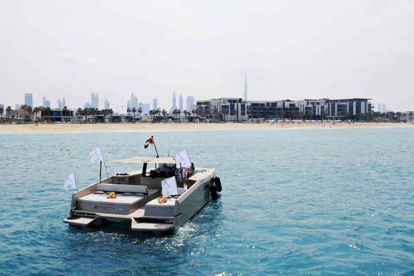 Ein Boot am Strand mit Flaggen im Hintergrund, in der Nähe von Dubai