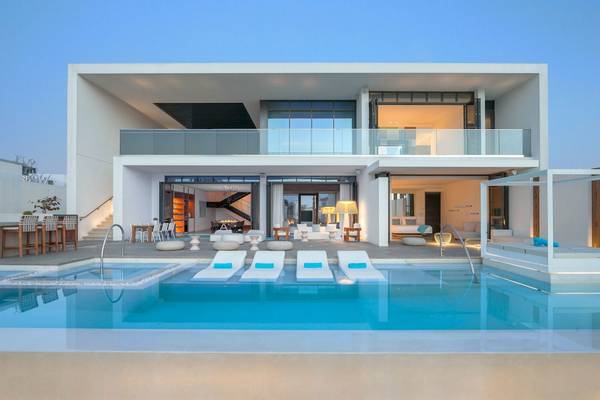 Außenansicht des Nikki Beach Resort & Spa Dubai mit Pool und modernen Möbeln.