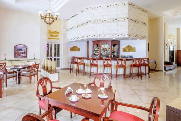 Innenbereich des Bella Mar Restaurants mit Bar, Tischen und Stühlen, einem Kronleuchter und Dekor.