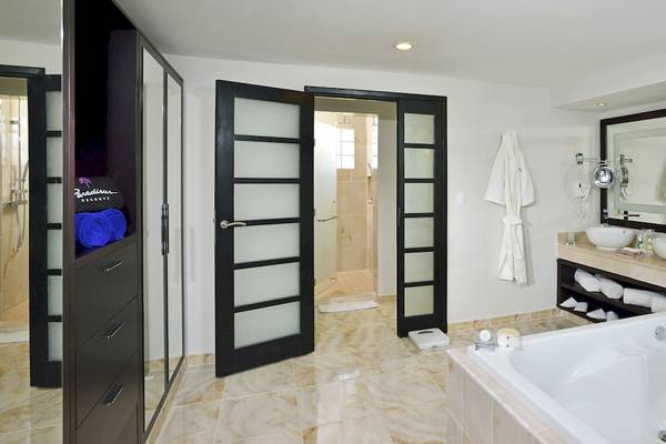 Ein modernes Badezimmer im Paradisus Varadero Resort & Spa mit einer Badewanne, zwei Waschbecken und einem großen Spiegel.